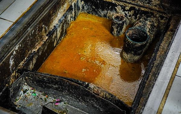 delaying grease trap cleaning can lead to foul odors, clogs, and even fines for non-compliance with regulations